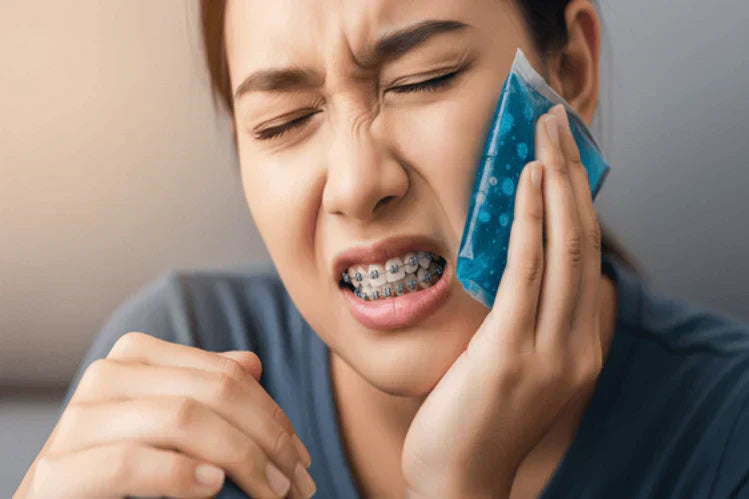 Seseorang yang memegang pek ais untuk melegakan kesakitan dan ketidakselesaan selepas mendapatkan pendakap gigi