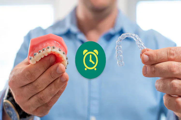 Seorang lelaki memegang model gigi dengan pendakap logam di sebelah tangan dan penjajar jelas di tangan yang lain