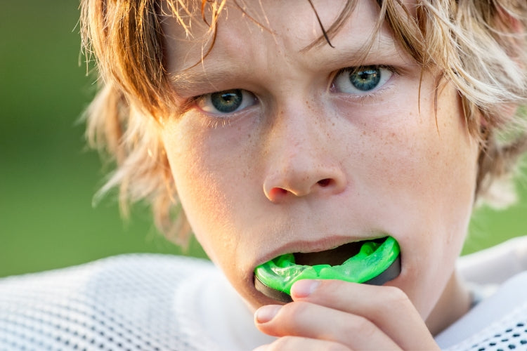 athlete using a mouth guard to protect his teeth